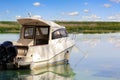 Big luxury fishing boat with cabin moored near river or lake shore in still water. Blue sky on the background. Summer adventure, Royalty Free Stock Photo