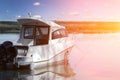 Big luxury fishing boat with cabin moored near river or lake shore in still water. Blue sky on the background. Summer Royalty Free Stock Photo