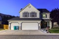 Big luxury house with triple garage doors at dusk, night in suburbs Royalty Free Stock Photo