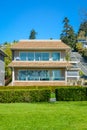 Big luxury residential house with green lawn in front on blue sky background. Royalty Free Stock Photo