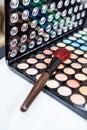 Big make up brush laying on box with different colors powder, close up view Royalty Free Stock Photo