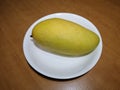 Big mango ripe has fresh yellow color on white dish.