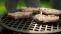 Big meat slices browning on grate. Juicy meat steaks frying on grill outdoors