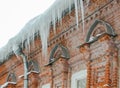 big Melting icicles hanging down from roof of the old brick building Royalty Free Stock Photo