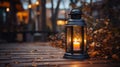 Big metal lantern with a burning candle inside, outdoors on the wooden ground