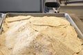 Big metal tray full of just cooked tortillas in industrial kitchen - selective focus