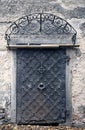 Big metallic old door. Historical house door, one timber leaf, closed black gateway.