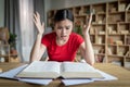 Big mistake. Amazed unhappy teenager chinese girl reading book, gesticulate in room or library interior Royalty Free Stock Photo