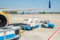 Big modern commercial plane parked on airport runway and connected to ground supply power unit. Aircraft maintenance