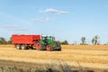 Big modern tractor trucker machine with full loaded with grain or silage wagon container trailer harvested wheat field Royalty Free Stock Photo