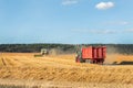 Big modern tractor trucker machine with full loaded with grain or silage wagon container trailer harvested wheat field Royalty Free Stock Photo