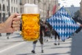 Glass of beer holding in hand at Oktoberfest in Munich Royalty Free Stock Photo