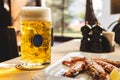 Big mug of fresh cold beer and fried tiger prawns on the table. A low-alcohol beverage and a snack are on the table. Light back Royalty Free Stock Photo