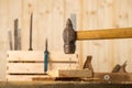 Big nail. A man in white gloves is hammering a big nail on the desk with black background. Shiny scrached hammer