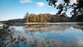 Big natural lake in forest on sunny summer midday with deep blue sky, still water surface, nature panorama tinted background photo