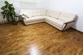 Big new beige sofa on wooden parquet floor Royalty Free Stock Photo