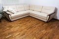 Big new beige sofa on wooden parquet floor Royalty Free Stock Photo