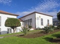Big new white villa at trditional azorean colonial style, with green flower garden and blue sky at Countryside at