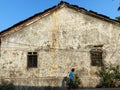 A big old house with rustic weathered walls and tiled sloping roofs in South Goa
