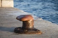 Big old rusty bollard on a stone pier Royalty Free Stock Photo