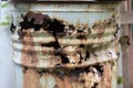 Big old rusty brown barrel with garbage with corrosion holes