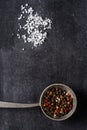 Big old spoon with peppercorn and salt pile on black background Royalty Free Stock Photo