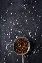 Big old spoon with peppercorn and salt pile on black background Royalty Free Stock Photo