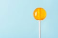 Big orange lollipop on blue background Royalty Free Stock Photo