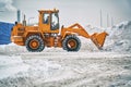 Big orange tractor removing snow