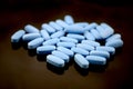 Big oval blue tablets closeup with sofl natural shadows and reflection on black background Royalty Free Stock Photo