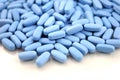 Big oval blue tablets closeup with sofl natural shadows and reflection on white background Royalty Free Stock Photo