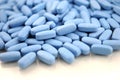 Big oval blue tablets closeup with sofl natural shadows and reflection on white background Royalty Free Stock Photo