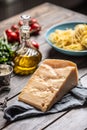 Big parmesan cheese slice on a table full of ingredients for Italian cuisine Royalty Free Stock Photo