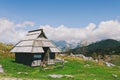 Big Pasture Plateau in the Kamnik Alps, Slovenia. Mountain cottage hut or house on green hill. Alpine meadow landscape. Farm