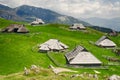 Big Pasture Plateau in the Kamnik Alps, Slovenia. Mountain cottage hut or house on green hill. Alpine meadow landscape. Farm