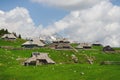 Big Pasture Plateau in the Kamnik Alps, Slovenia. Mountain cottage hut or house on green hill. Alpine meadow landscape. Farm