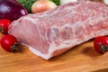 Uncooked pork loin and vegetables on cutting board close-up Royalty Free Stock Photo