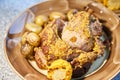 The big piece of the grilled stewed pork with mustard sauce lies on a plate with potatoes and corn, Juicy meat Royalty Free Stock Photo