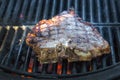A big piece of meat with mouth-watering strips from grilling. Grilled beef steak with flames.