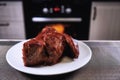 Big piece of meat on plate. Roast beef close-up. Barbecue meat in modern kitchen. Blurred background oven. Hot cooked dinner. Royalty Free Stock Photo