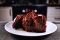 Big piece of meat on plate. Roast beef close-up. Barbecue meat in modern kitchen. Blurred background oven. Hot cooked dinner. Huge