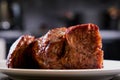 Big piece of meat on plate. Roast beef close-up. Barbecue meat in modern kitchen. Blurred background oven. Hot cooked dinner. Side Royalty Free Stock Photo