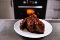 Big piece of meat on plate. Roast beef close-up. Barbecue meat in modern kitchen. Blurred background oven. Hot cooked dinner. Royalty Free Stock Photo