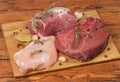 Different uncooked meat, spices on cutting board on rustic table