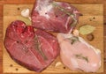 Different uncooked meat and spices on cutting board, top view