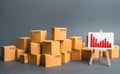 A big pile of cardboard boxes and a stand with information chart. Increasing consumer demand, exports or imports. rate growth Royalty Free Stock Photo