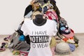 Big pile of clothes thrown on the ground with a t-shirt saying nothing to wear.