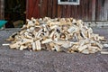 big pile of firewood infront of red barn