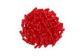 Big pile heap of bright red licorice sweet candy treat on a bright white studio counter table as a food scene