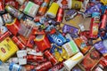 Big pile of many disposable colored trash from edible products of famous food and beverage manufacturers. Soda cans and chocolate